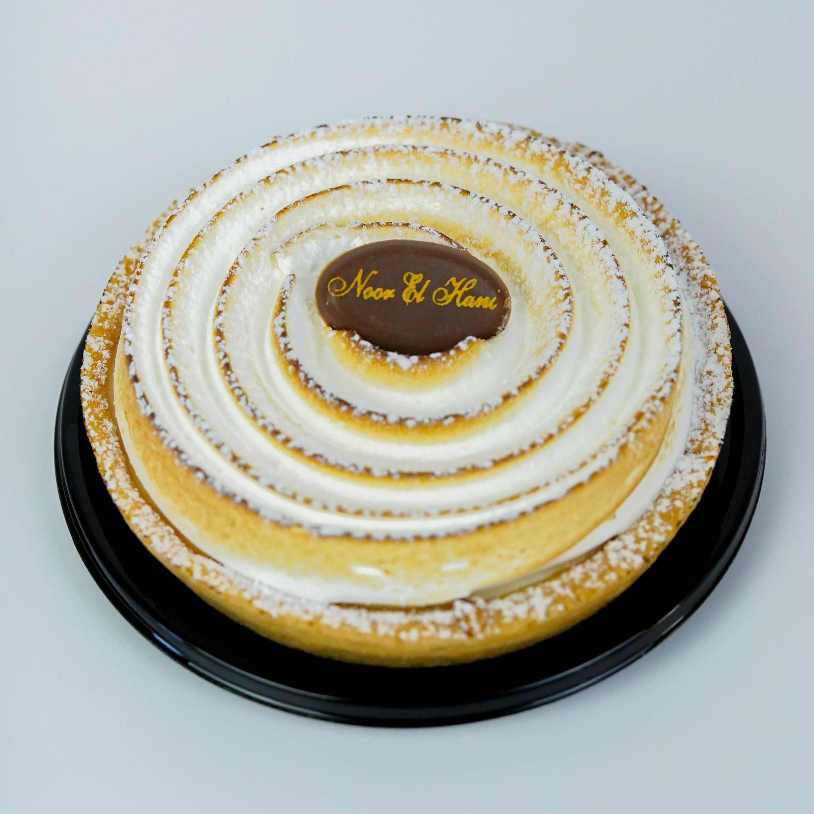 {"fr":"urn of a dessert with white icing and chocolate on top, the word \"Noon\" written in gold letters, a black rim around the edge of the plate — restauration","en":"urn of a dessert with white icing and chocolate on top, the word \"Noon\" written in gold letters, a black rim around the edge of the plate — restauration","ar":"urn of a dessert with white icing and chocolate on top, the word \"Noon\" written in gold letters, a black rim around the edge of the plate — restauration"}